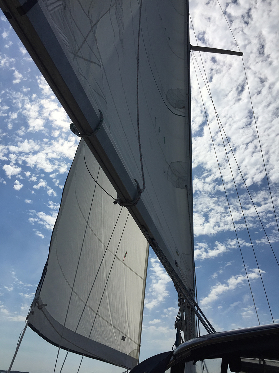 The wind catching the sails on a sailboat
